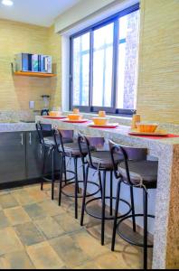 Il comprend une cuisine avec un bar et des chaises. dans l'établissement La ocotera hotel de montaña, à San Marcos