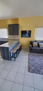 a living room with a kitchen and a couch at Finest Accommodation Caribbean Estate Lot 78 in Portmore