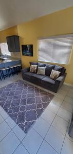 Finest Accommodation Caribbean Estate Lot 78 في بورتمور: غرفة معيشة مع أريكة ومطبخ