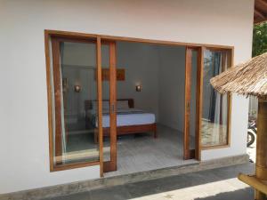 Habitación con cama y puertas correderas de cristal en Vera Koe, en Kuta Lombok