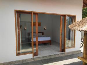 a room with a bed and sliding glass doors at Vera Koe in Kuta Lombok