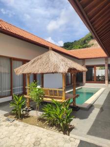 un complejo con banco y piscina en Vera Koe, en Kuta Lombok