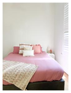 uma cama com lençóis e almofadas cor-de-rosa em HAVEN: Stunning Unley *history*location*charm 3bd em Unley