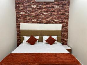 a bedroom with a bed with a brick wall at Hotel Paradise Dream in Ludhiana