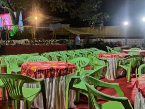a row of tables and chairs with red and green table cloths at PARK RESORT MATHERAN in Matheran