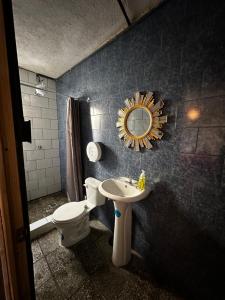 a bathroom with a sink and a toilet and a mirror at CASA MAGNOLIA in Guatemala