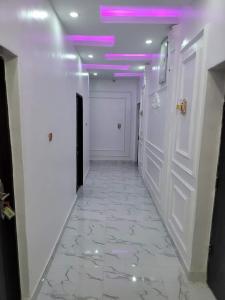 un corridoio con pareti bianche e soffitto viola di B&Y ROYAL BAR & LOUNGE ADIGBE ROAD ABEOKUTA ad Abeokuta