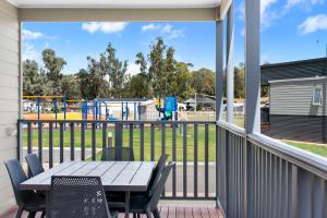 a patio with a table and chairs and a playground at Waikerie Holiday Park in Waikerie