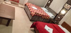 two beds in a room with a red blanket on the floor at PARK RESORT MATHERAN in Matheran