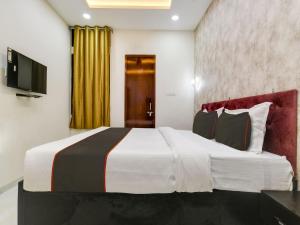 Hotel Iconic Stay في إندوري: غرفه فندقيه سرير كبير وتلفزيون