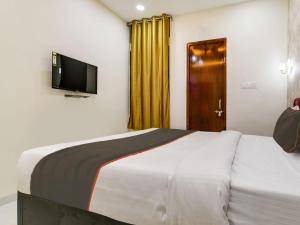 Schlafzimmer mit einem Bett und einem Flachbild-TV in der Unterkunft Hotel Iconic Stay in Indore