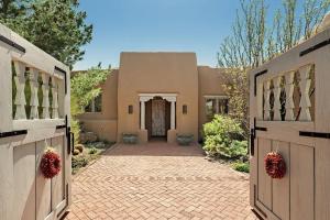 a house with a gate and a driveway at Villa Namaste-Mountain View Home in Santa Fe