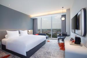 Postel nebo postele na pokoji v ubytování HARRIS Hotel & Convention Cibinong City Mall Bogor