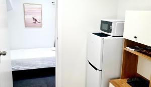 a room with a refrigerator and a microwave at Golden Sands Motor Inn in Forster