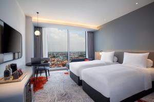 Postel nebo postele na pokoji v ubytování HARRIS Hotel & Convention Cibinong City Mall Bogor