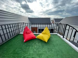 two colorful pillows sitting on a balcony at ATPoolVillaHuaHin เอทีพูลวิลล่าหัวหิน in Ban Wang Bot