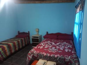 a bedroom with a bed with a red bedspread at Casa de familia in Cachí