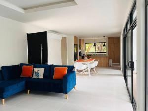 a living room with a blue couch and a dining room at Casa Bellota in Marbella