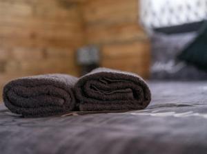 uma pilha de toalhas sentadas em cima de uma cama em Diamond Vault Rustic Mountain Cabins em Hogsback