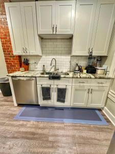 a kitchen with white cabinets and a sink at Modern Luxe 3BR/1BA with Bar in Columbus