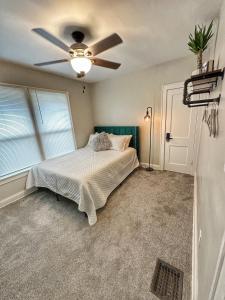 a bedroom with a bed and a ceiling fan at Modern Luxe 3BR/1BA with Bar in Columbus