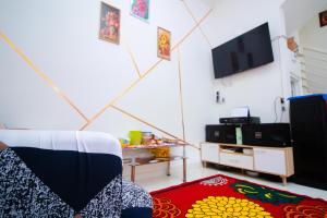 un salon avec une télévision et un tapis dans l'établissement Villa 17 Celcius Private Pool and Rooftop, à Tlekung