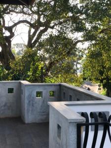 a bench sitting on top of a concrete wall at senarathna guest house in Weligama