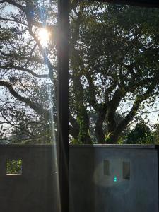 una vista del sole che splende dietro una recinzione di senarathna guest house a Weligama