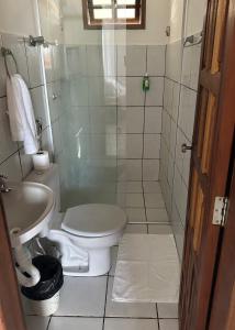 a bathroom with a toilet and a shower and a sink at Residencial Castelinho in Mucuri