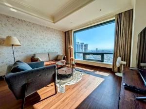 a living room with a couch and a large window at 台中自由行 in Taichung