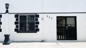 un edificio blanco con una puerta y ventanas negras en Confortable Loft MN 960 C Centro Mty cerca de todo, en Monterrey