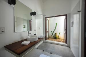 a bathroom with a sink and a window with a cactus at Minnehaha Bentota in Bentota