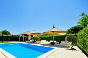 einen Pool mit Stühlen und Sonnenschirmen neben in der Unterkunft Bliss Residences Biograd Apartments - Happy Rentals in Biograd na Moru