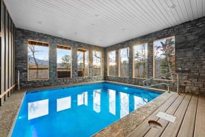 a swimming pool in a house with windows at Hidden Gem Masterpiece By Ghosal Luxury Lodging in Gatlinburg