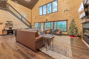 a living room with a couch and a christmas tree at Hidden Gem Masterpiece By Ghosal Luxury Lodging in Gatlinburg
