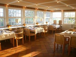 Ferienwohnung auf Hiddensee im Ort Kloster في كلوستر: غرفة طعام مع طاولات وكراسي ونوافذ