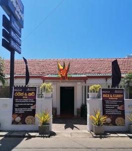 a restaurant with signs in front of a building at Villa Fernando Resort in Chilaw