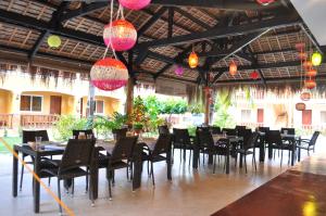 una sala da pranzo con tavoli, sedie e luci di SLAM'S Garden Dive Resort a Isola di Malapascua