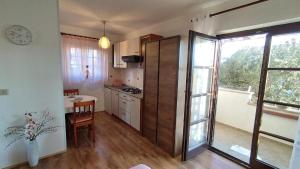uma cozinha com uma mesa e uma grande porta de vidro deslizante em Studio für 2 Personen ca 25 qm in Novigrad, Istrien Istrische Riviera - b44338 em Karpinjan