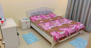 a bedroom with a bed with a pink comforter at marena in Ajman 