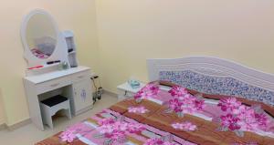 a bedroom with a bed with a dresser and a mirror at marena in Ajman 