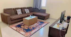 a living room with a brown couch and a table at marena in Ajman 