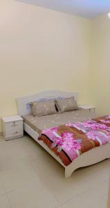 uma cama grande num quarto com uma parede branca em marena em Ajman