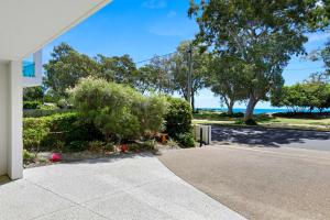 a walkway in front of a house with the ocean in the background at Beachfront Nirvana in Urangan