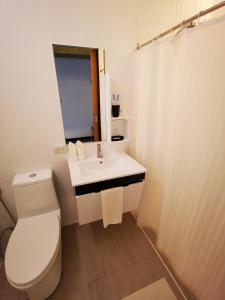 a white bathroom with a toilet and a sink at Urban Boutique Hotel in Boracay