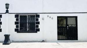 a white building with a black door and windows at Confortable Loft MN 960 D Centro Mty cerca de todo in Monterrey