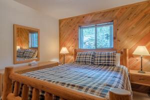 - une chambre avec un lit et un mur en bois dans l'établissement Smokey Plaza Condo 1 - Just Blocks from Bald Mountain & Hot Tub Onsite, à Ketchum