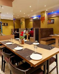 une salle à manger avec une table et des personnes dans un restaurant dans l'établissement The Ganga Residency, à Bārh