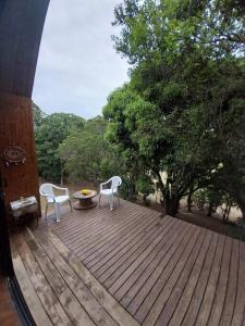 two chairs and a table on a wooden deck at Chalé da Colina Florianópolis in Florianópolis