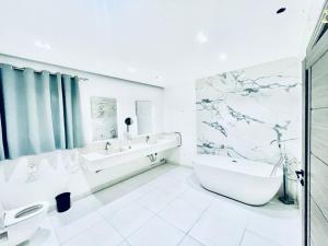 a white bathroom with a tub and a sink and a bath tub at Rove Residence New Cairo in Cairo